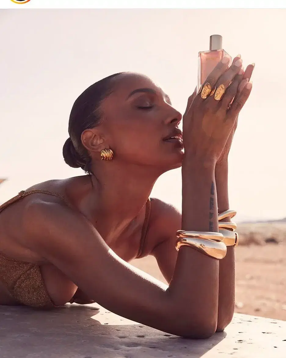 Woman holding a perfume bottle near her face